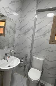 a bathroom with a white toilet and a sink at Spacious Apartment In 6 October in 6th Of October +14 photos