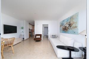 a living room with a white couch and a table at Lighthouse - Exclusive Sea view 180º, pool, parking in Portimão