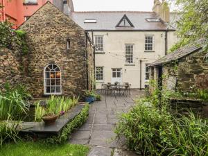 an old stone house with a patio in the yard at The Secret Garden in Narberth