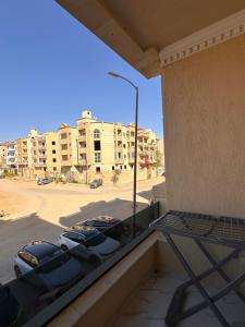a balcony with cars parked in a parking lot at Spacious Apartment In 6 October in 6th Of October