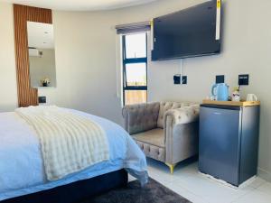 a bedroom with a bed and a couch and a television at Lifestyle Villas in Sipilini