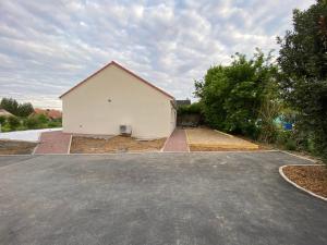 a large white garage with a driveway at La Campagnarde in Pargny