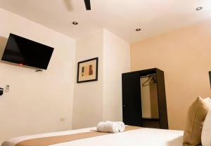 a bedroom with a bed with a flat screen tv on the wall at Hotel Zibahun in Valladolid +84 photos
