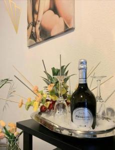 a bottle of wine sitting on a tray with a glass at Visconti suite and spa in Catania +35 photos