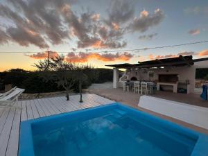 a house with a blue swimming pool on a deck at Pambelos Lodge in Koufonisia