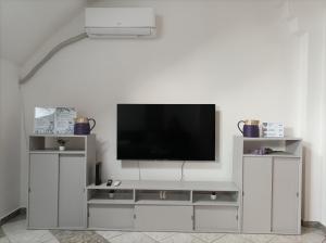 a white entertainment center with a flat screen tv at Levendula Apartman in Bačka Topola
