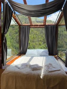 a bed in a room with a large window at Mountain Paradise in Merisi 2 in Merisi