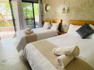 ein Schlafzimmer mit zwei Betten und einem Fenster in der Unterkunft Hotel Casa Grangelo in Atlixco + 100 Fotos
