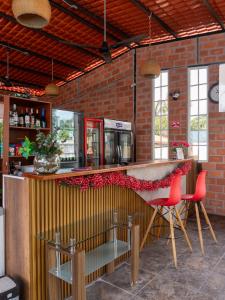 a bar with two red chairs and a counter at Salamandras Hostería & Spa in Tena