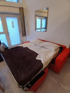 a bed in a room with a mirror and a red chair at MILANO Central Station House in Milan