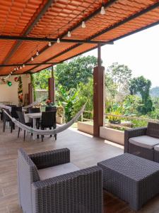 an outdoor patio with chairs and tables and a hammock at Salamandras Hostería & Spa in Tena