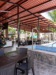 a patio with a table and chairs and a swimming pool at Salamandras Hostería & Spa in Tena