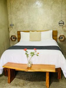 ein Bett mit einer Blumenvase auf einem Holztisch in der Unterkunft Hotel Casa Grangelo in Atlixco