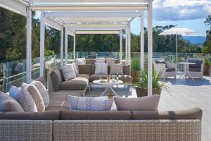 a patio with couches and tables and an umbrella at The Clement Hotel in Palo Alto