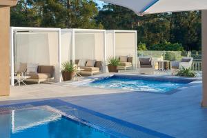 a swimming pool with chairs and a table and an umbrella at The Clement Hotel in Palo Alto