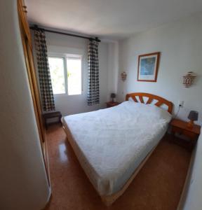a bedroom with a white bed and a window at Casa Gaia in La Manga del Mar Menor