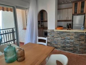 a kitchen with a wooden table with chairs and a counter at Casa Gaia in La Manga del Mar Menor