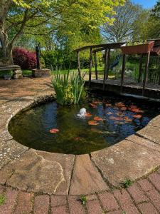 a pond with a kite in the middle of a garden at Maesbury Riverside in Oswestry