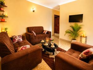 a living room with two couches and a table at Palm Star Motel in Fort Portal