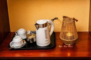 a tray with a tea kettle and cups on a table at Palm Star Motel in Fort Portal