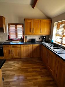 a kitchen with wooden cabinets and black counter tops at Maesbury Riverside in Oswestry
