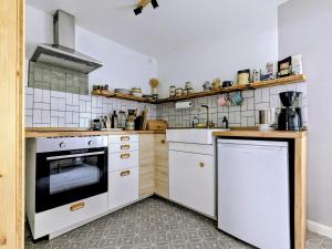 a kitchen with white cabinets and a stove at Ferienhaus Glockenklang in Sangerhausen