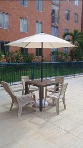 a picnic table and two chairs with an umbrella at Apartamento Amoblado en Ibague in Ibagué