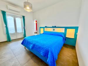 a bedroom with a blue bed and a window at Casa Mimi in Praiano