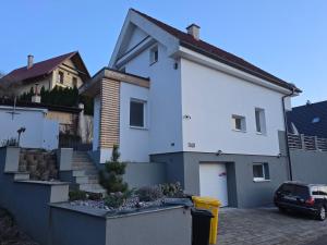 a white house with a parking lot in front of it at Dom pri jazere Nitrianske Rudno in Kostolná Ves