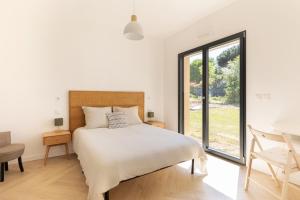 a bedroom with a bed and a large window at Villa Anita in Chevreuse