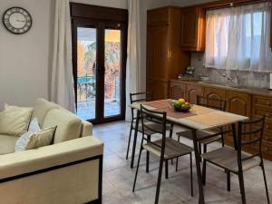 a kitchen and dining room with a table and a couch at Val's place in Mytilene