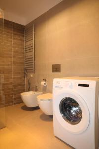 a bathroom with a washing machine and a toilet at City Views Apartment in Shkodër +16 photos