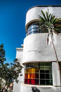 a building with a palm tree in front of it at Hostel Hotzenplotz Alegre in Valparaíso +18 photos