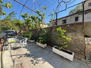 a patio with tables and chairs and a brick wall at Canyon River House in Çorovodë