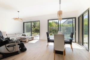 a dining room and living room with a table and chairs at Villa Anita in Chevreuse