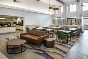 a restaurant with tables and chairs and a couch in a room at TownePlace Suites by Marriott Reno in Reno