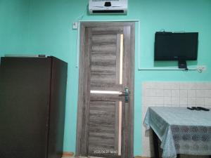 a door in a room with a television and a table at Гостевой дом Туманян in Tʼumanyan