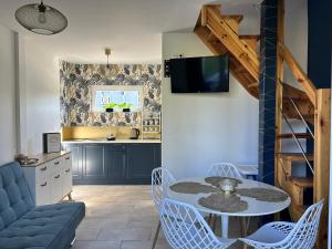 a living room with a table and chairs and a kitchen at Poprzeczna 7 in Sarbinowo