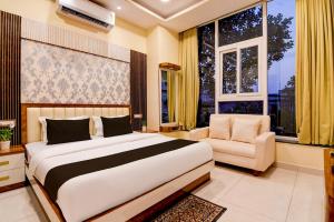 a bedroom with a bed and a chair and windows at Super Townhouse Hotel All In One in kolkata