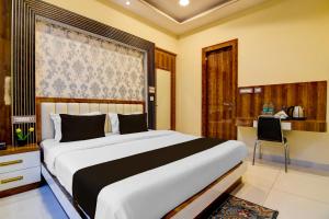 a bedroom with a large bed and a desk at Super Townhouse Hotel All In One in kolkata