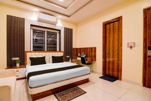 a bedroom with a bed and a desk and a window at Super Townhouse Hotel All In One in kolkata