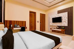 a hotel room with a bed and a tv at Super Townhouse Hotel All In One in kolkata