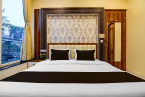 a bedroom with a large white bed with a window at Super Townhouse Hotel All In One in kolkata +23 photos