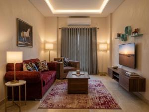a living room with a couch and a tv at Soly Apartments in Hurghada