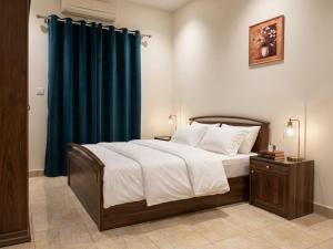 a bedroom with a large bed with a blue curtain at Soly Apartments in Hurghada +13 photos