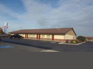 a building with a car parked in a parking lot at Huggy Bear Motel - Warren in Warren