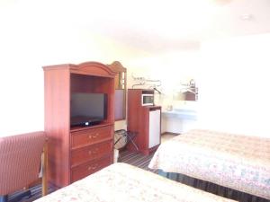 a hotel room with two beds and a television at Huggy Bear Motel - Warren in Warren +5 photos