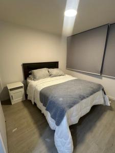 a bedroom with a bed and a chalkboard on the wall at Moderno Departamento Viña del Mar in Viña del Mar