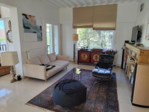a living room with a couch and a chair at la villa avezard in Blonville-sur-Mer +11 photos