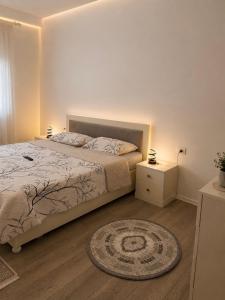 a bedroom with a bed and a rug on the floor at ARMAS Stay in Kamëz